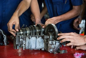 Students in technical college working on a transmission
